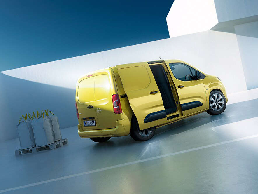 Вигляд збоку на Opel Combo Cargo жовтого кольору з відчиненими відсувними дверима з правого боку