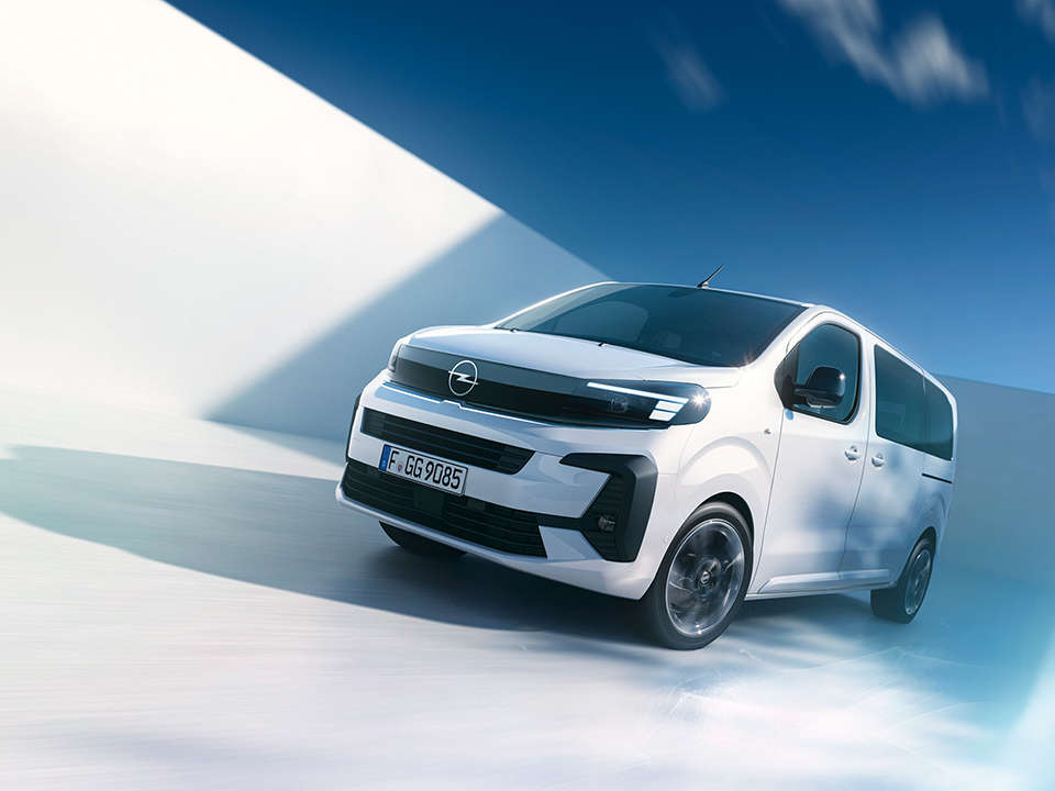 Вигляд спереду з лівого боку на Opel Zafira білого кольору у русі